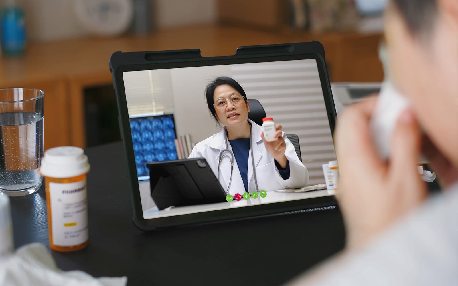 Doctor on video call explaining medication to patient at home