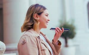 Woman using voice AI on smartphone outdoors